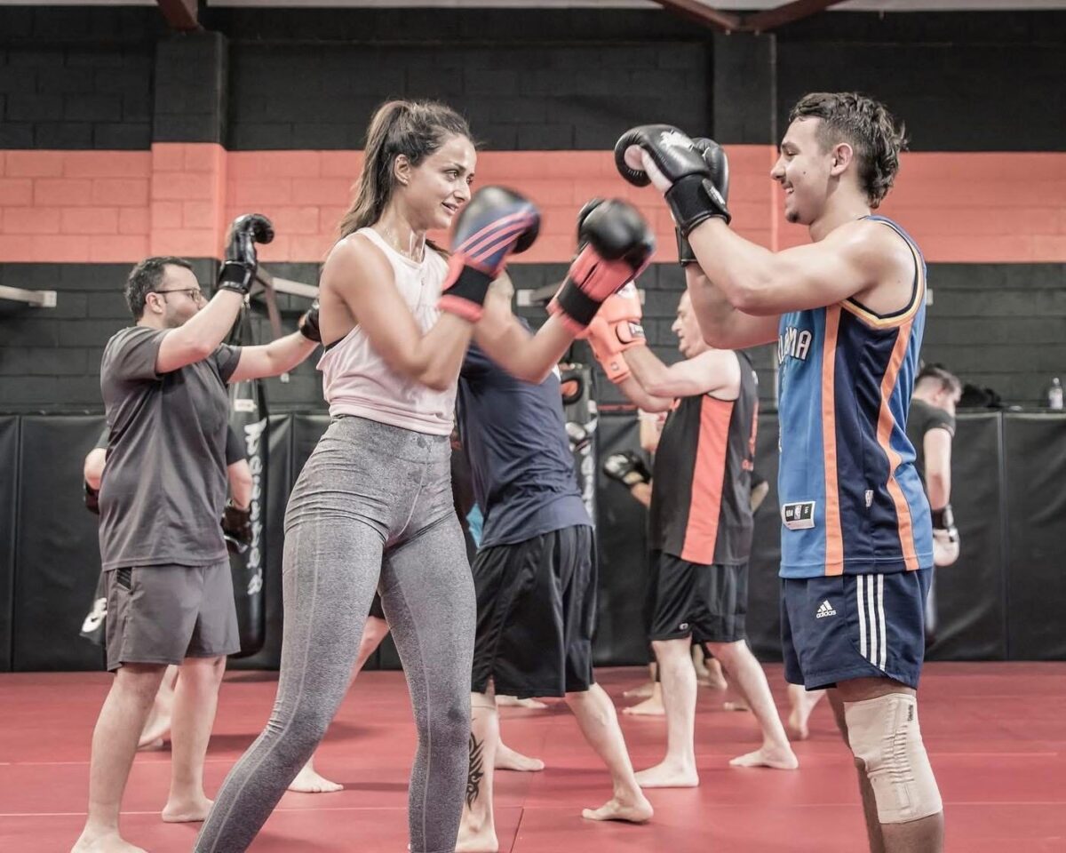 Adults working in pairs with boxing gloves during a class at Chau Kaizen in Prospect, Adelaide