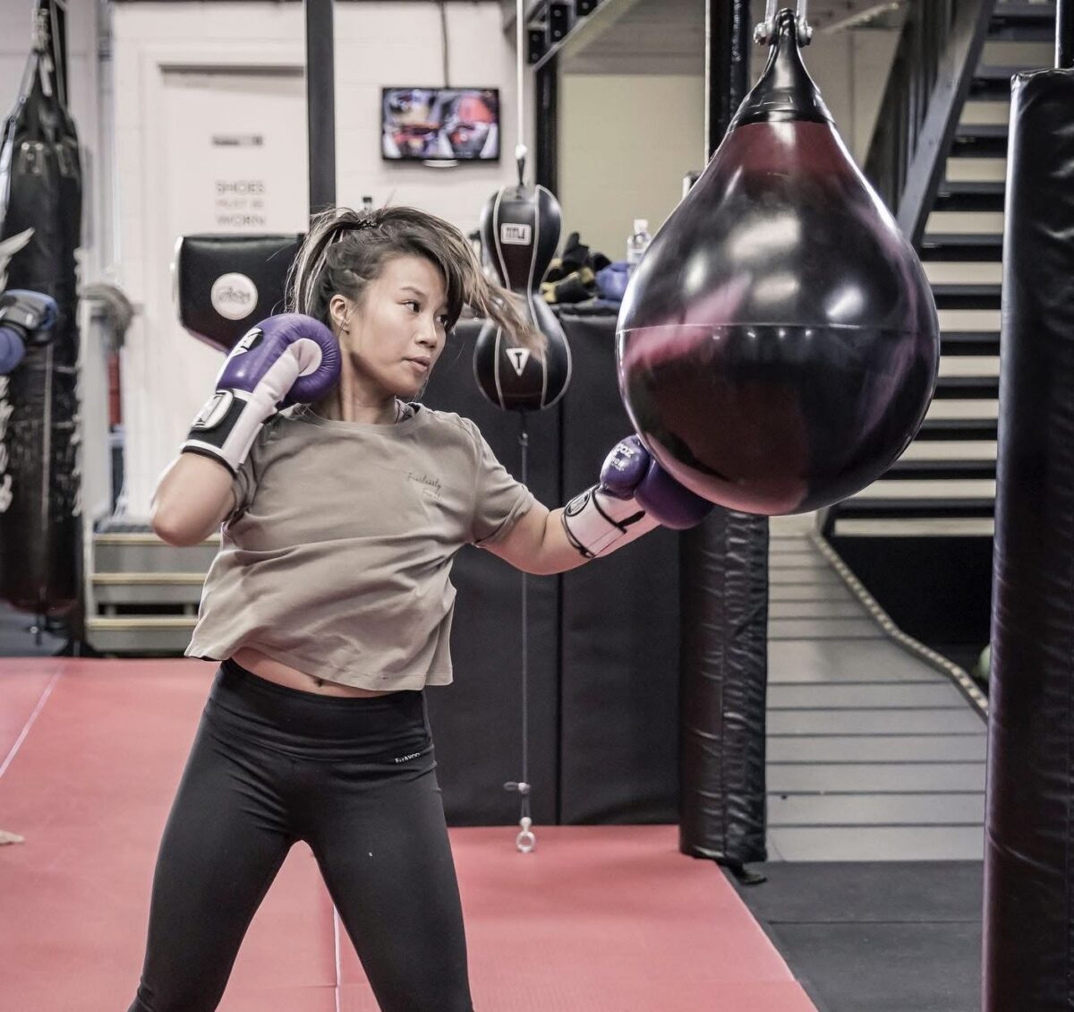 Member throwing an uppercut into an aqua bag during a fitness kickboxing class at Chau Kaizen