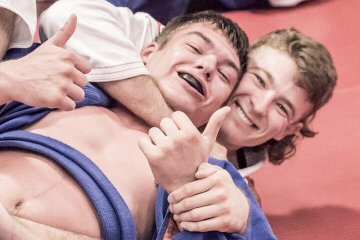 Two members in blue gis laughing during Brazilian Jiu Jitsu training at Chau Kaizen in Prospect, Adelaide