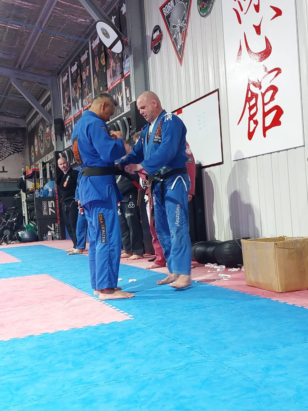 Suasday Chau receiving his Brazilian Jiu Jitsu black belt from Mick Moloney in September 2023